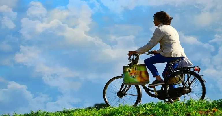 Pessoa andando de bicicleta ao ar livre em um dia ensolarado, representando um hábito minimalista simples.