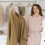 Mulher indecisa escolhe look em um closet minimalista com guarda-roupa cápsula.