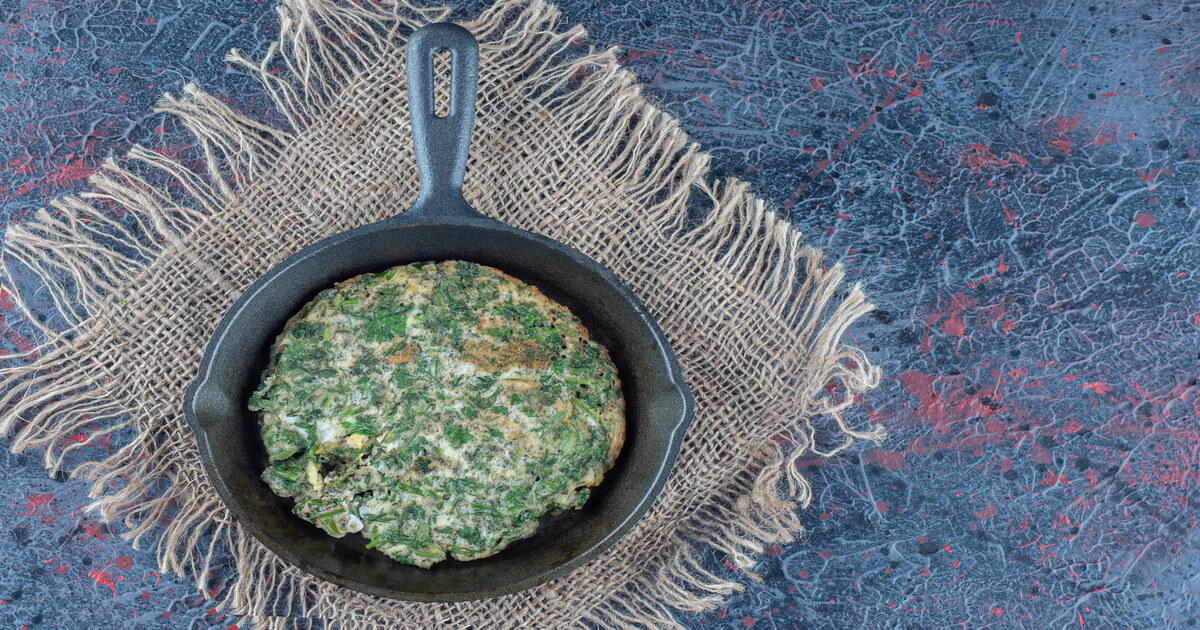 Omelete de talos de espinafre em frigideira de ferro, uma opção saudável e sustentável dentro das receitas sustentáveis.