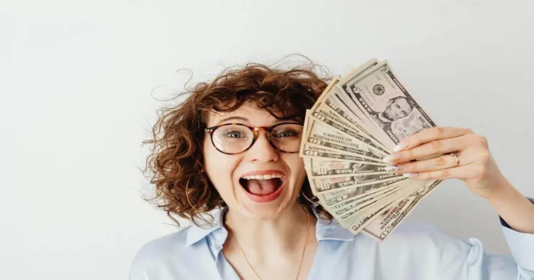 Mulher sorridente segura notas de dólar, representando alegria ao alcançar a liberdade financeira com escolhas conscientes.