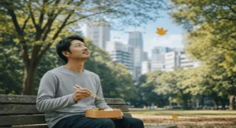 Homem em parque de Tóquio, marmita no colo e hashis, olhando a folha caindo; o significado de perfect days.