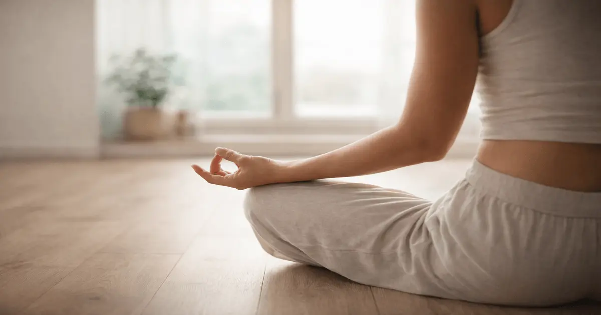 Pessoa meditando em ambiente claro com gesto de mão simbolizando o que são chakras e conexão com energia interior.