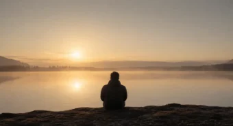 Silhueta contemplando lago ao amanhecer em névoa dourada, solidão consciente inspirada em Walden.